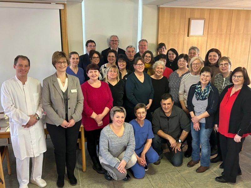 Gruppenfoto von Mitarbeitern des Nardini Klinikums in Landstuhl, feierliche Atmosphäre.