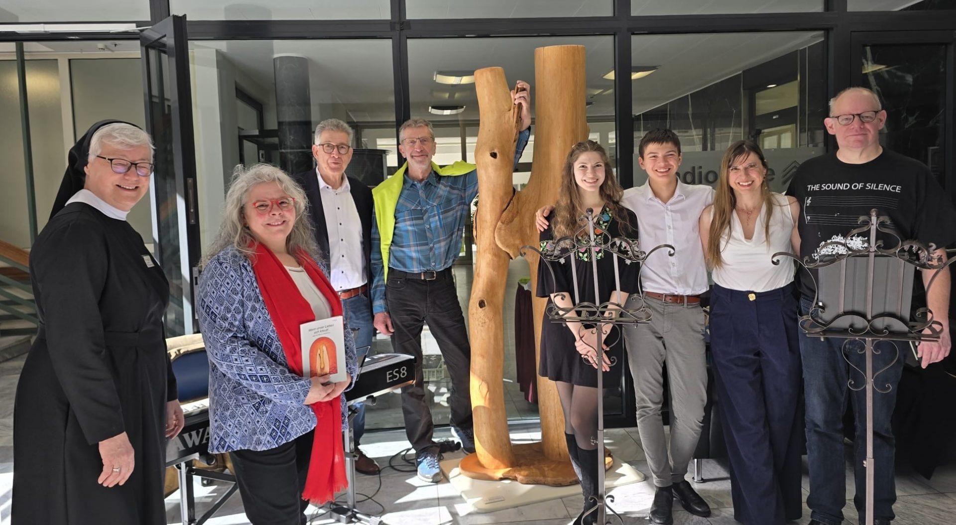 Gruppe von Personen bei einer Ausstellung im Nardini Klinikum in Landstuhl, umgeben von Kunstwerken.