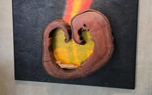 Abstrakte Holzskulptur mit gelben und roten Farbtönen.